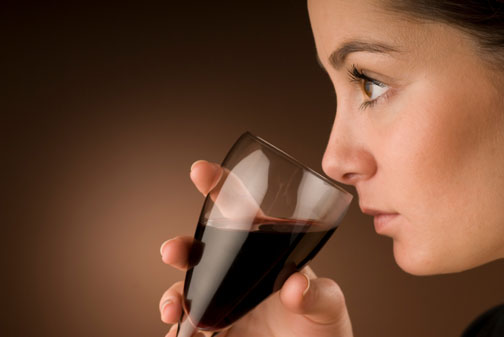 A beatiful young woman is tasting wine